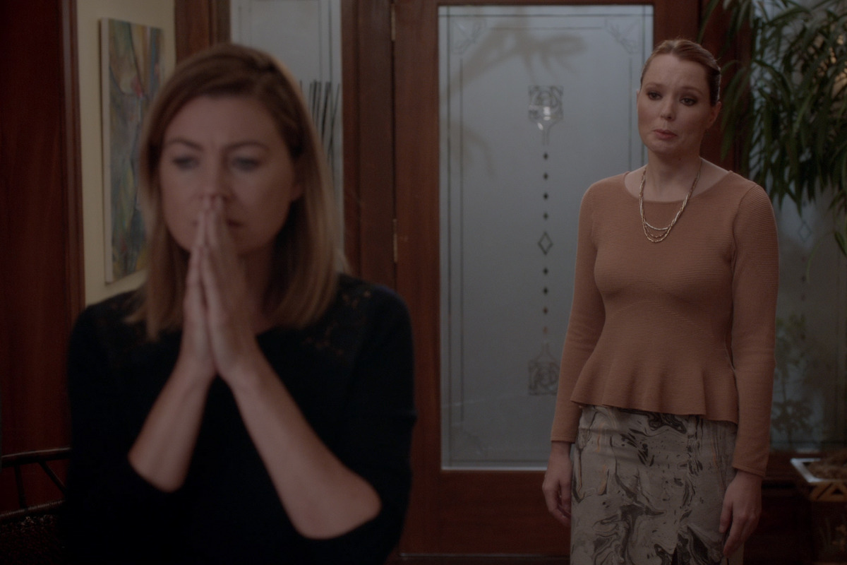 Meredith looks solemnly away from the woman at her front door