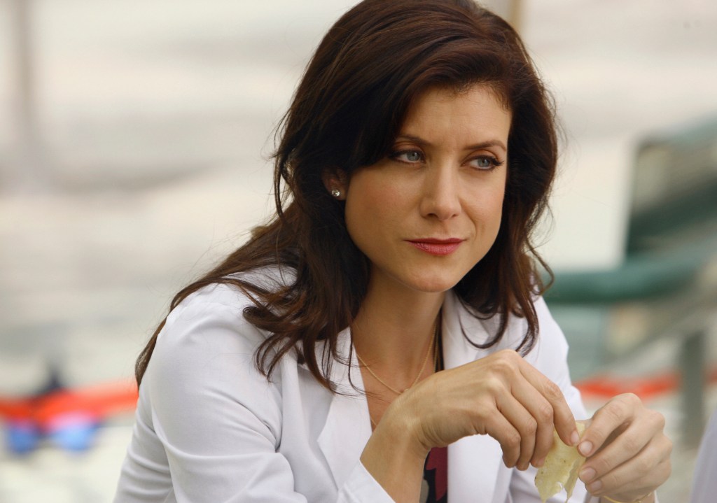 'Grey's Anatomy' actor Kate Walsh as Addison Montgomery smirking while wearing a white lab coat.
